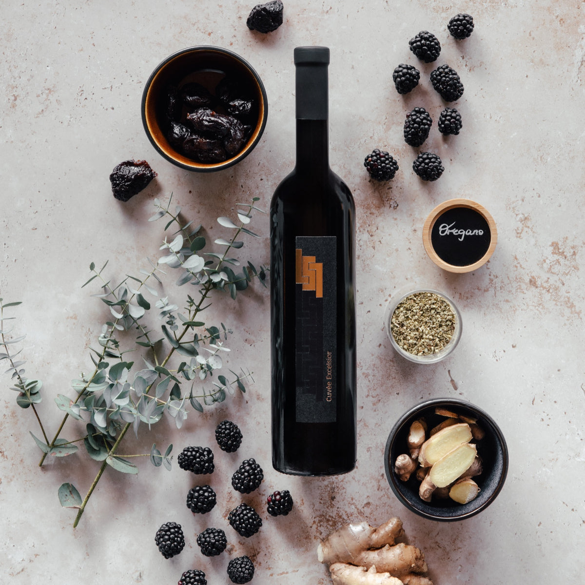Excelsior-Flasche im Aromen-Stillleben mit Brombeeren, Ingwer, Oregano und Eukalyptus